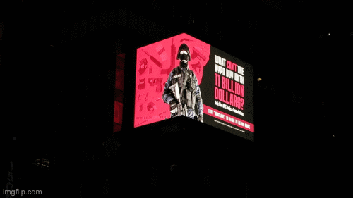 Color Of Change digital billboard in Times Square, NYC. Foreground: Photo of a NYPD officer decked out in full riot gear, carrying military-style weapons. In the background: Various militarized weapons and police tools, including Tazers, nightstick, gas masks, handgun, and rifles. Text reads: 'What CAN'T the NYPD buy with 11 billion dollars? Ask the NYC Police Foundation. Text "DISCLOSE" to 55156 to learn more.'