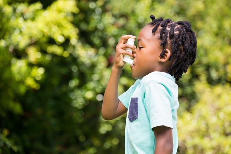 Profile image of a Black child using an asthma pump